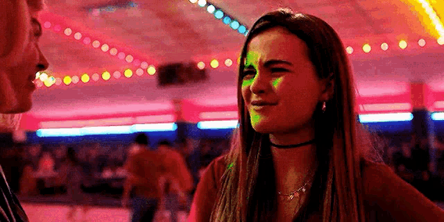 a woman is standing next to a man in a roller rink .
