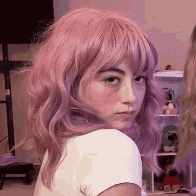the girl is wearing a pink wig and a white shirt .