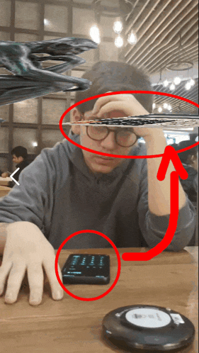 a man is sitting at a table with a cell phone on it