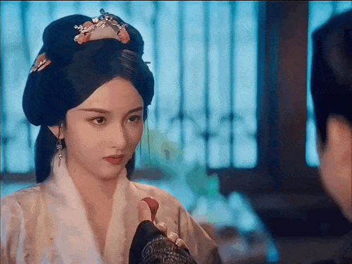 a woman in a white robe is looking at a man