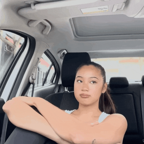a woman sits in the back seat of a car