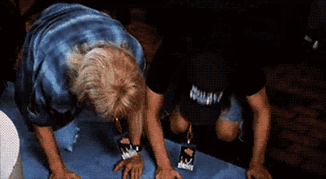 a man wearing a black shirt that says ' nirvana ' on it is kneeling down
