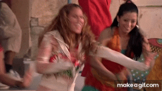 a group of women are dancing together in a room and one of them is wearing a cast on her leg .