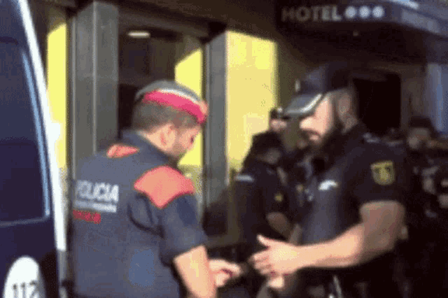 a group of police officers stand in front of a hotel