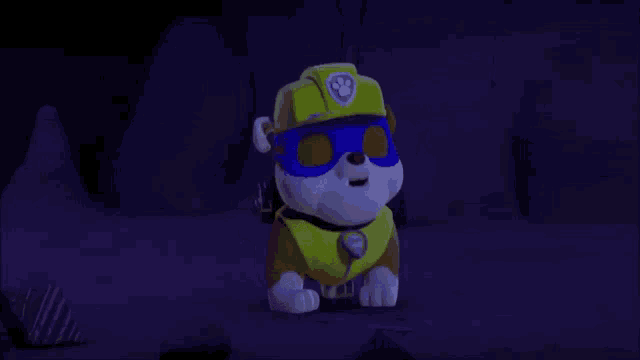 a cartoon dog wearing a mask and a yellow vest is standing in a dark cave .