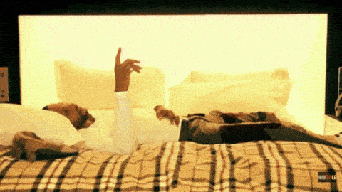 a man laying on a bed with a plaid blanket and a sign that says how to lee on it