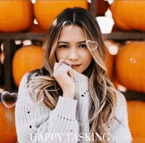 a woman in a sweater is surrounded by pumpkins and soap bubbles with the words happy tasking written below her