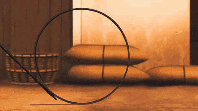 a circle with a needle sticking out of it sits on a wooden floor