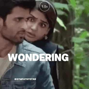 a man and a woman are standing next to each other in the woods and the woman is looking at the man .