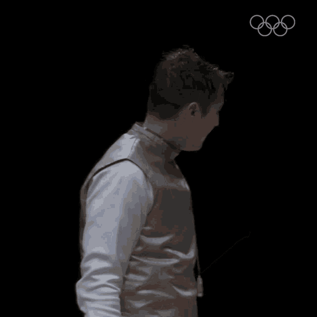 a man wearing a fencing vest with the olympic rings in the corner