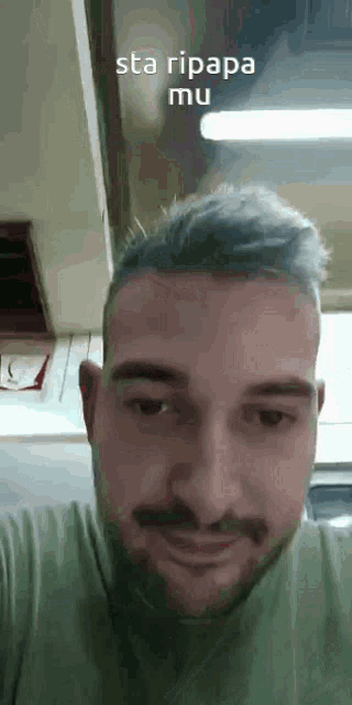 a man with a beard and a mustache is looking at the camera and smiling .