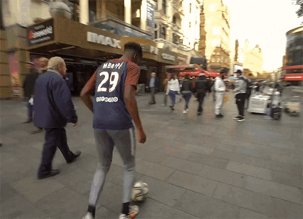 a man wearing a shirt with the number 29 on it is kicking a soccer ball