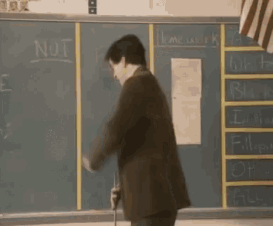 a man is standing in front of a blackboard that says not on it