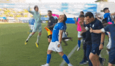 a group of soccer players are celebrating on the field and one of them is wearing a shirt that says ' uefa '