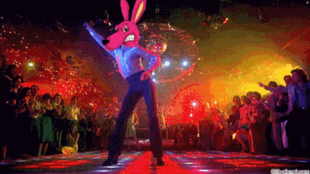 a man in a bunny mask is dancing in a disco