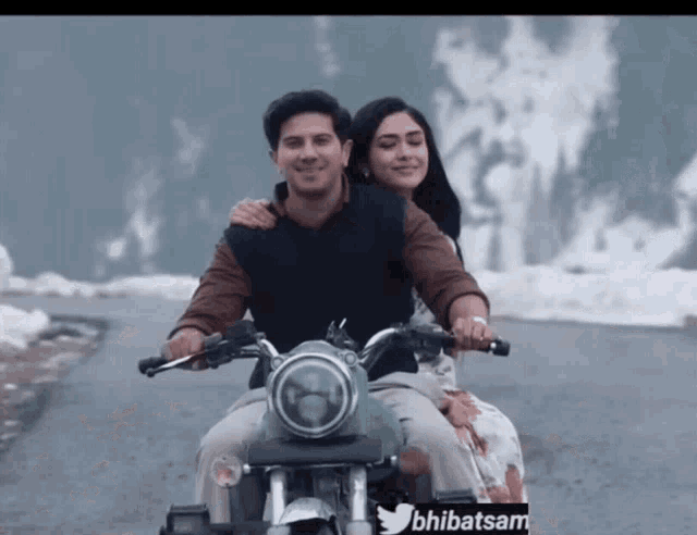a man and a woman are riding a motorcycle with a license plate that says ' bhlibatsam ' on it