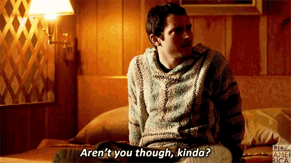 a man sitting on a bed with the words aren 't you though kinda