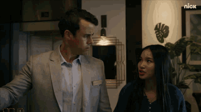a man in a suit and a woman in a blue shirt are standing next to each other in a nick ad