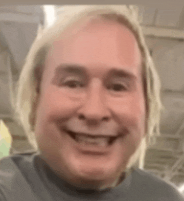 a close up of a man 's face smiling in a room .