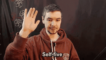 a man in a maroon hoodie is waving his hand and says self-five
