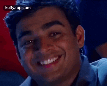 a close up of a man smiling with his mouth open and his teeth showing .