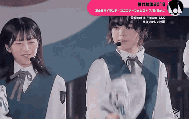 two girls are standing next to each other and one has a microphone in her mouth