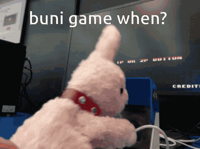 a stuffed bunny is playing a video game with the words " buni game when " written on the screen