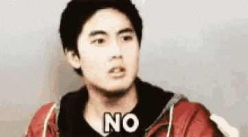 a young man in a red jacket is making a face and saying no .
