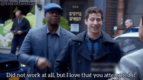 two men standing in front of a building that says ' did not work at all but i love that you attempted it ' on it