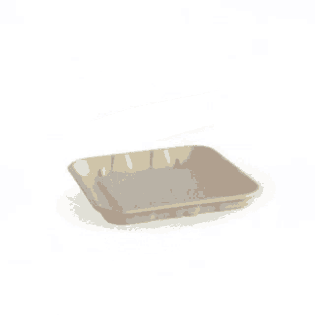 a beige bowl is sitting on a white surface