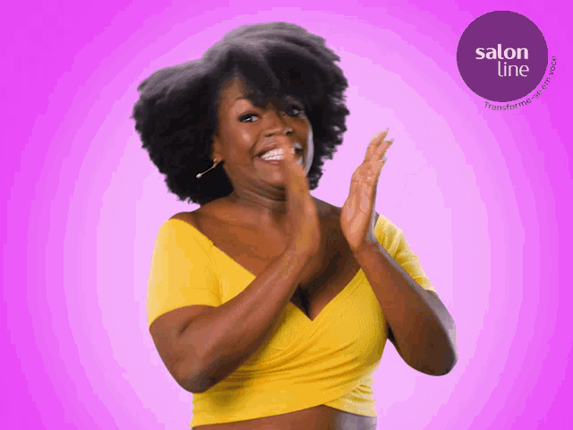 a woman in a yellow top is clapping in front of a sign that says salon line