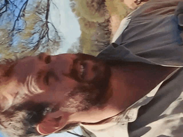 a man with a beard is smiling and looking at the camera