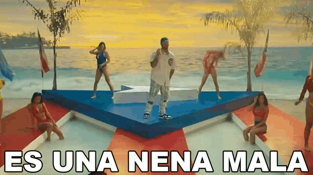 a man stands on a stage surrounded by women with the words es una nena mala written above him