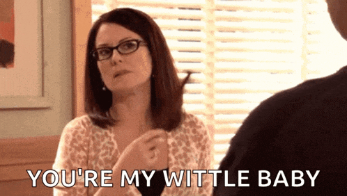 a woman wearing glasses is talking to a man and says you 're my wittle baby