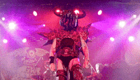a man in a demon costume is standing on a stage holding a microphone