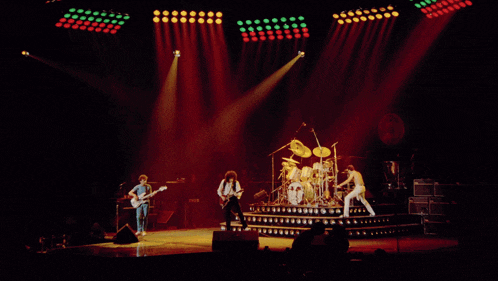 a group of people playing instruments on a stage with red and green lights