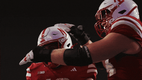 a football player wearing a red and white uniform with big on the front