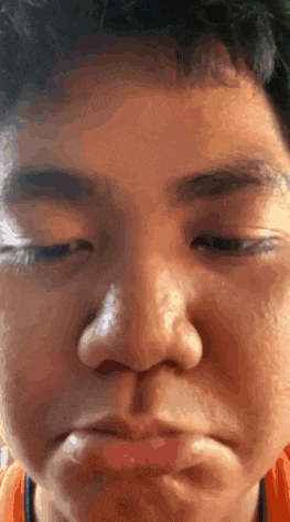 a close up of a young boy 's face with his eyes closed .
