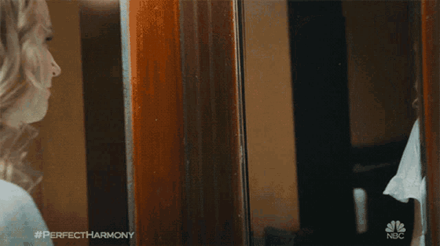 a woman looking at herself in a mirror with #perfectharmony