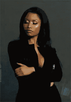 a woman in a very plunging black dress is standing with her arms crossed