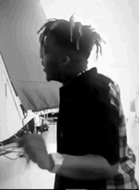 a black and white photo of a man with dreadlocks