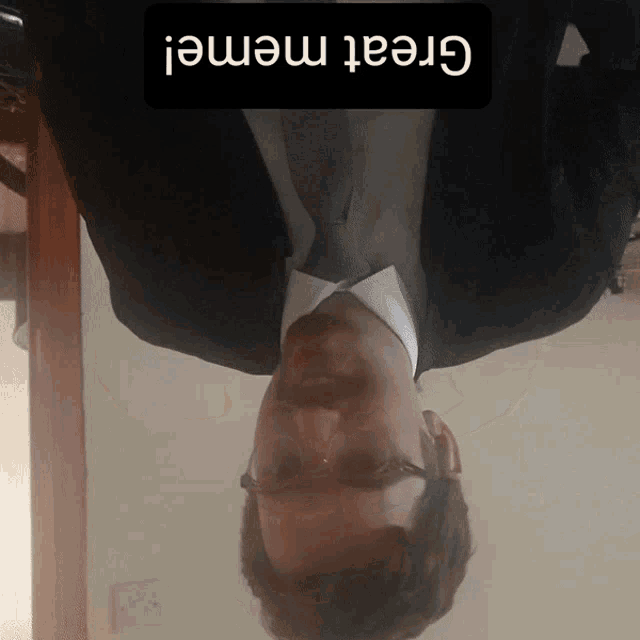 a man in a suit and tie is upside down with a great meme written above him