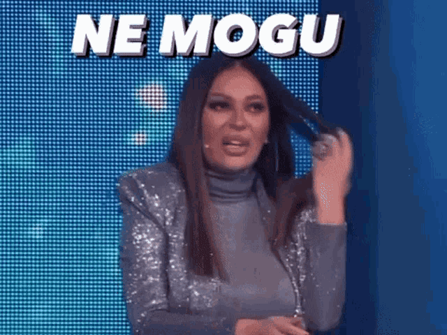 a woman in a sequined jacket is holding her hair in front of a blue screen that says ne mogu .