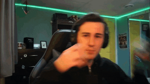 a man wearing headphones is sitting in a chair in front of a mirror