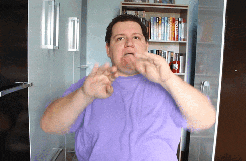 a man wearing a purple shirt is making a funny face