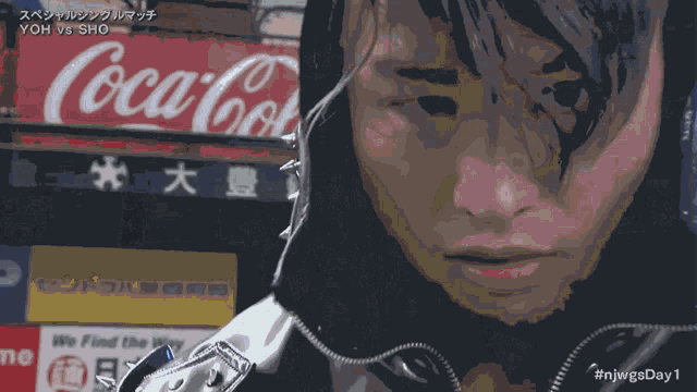 a coca cola sign is behind a person 's face