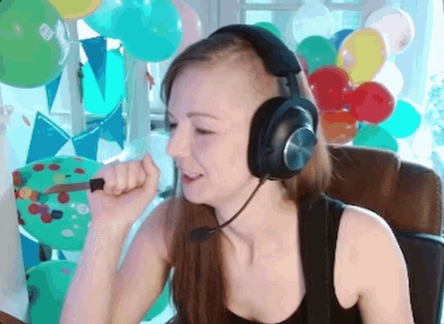 a woman wearing headphones holds a knife in her mouth