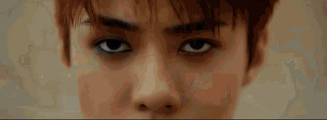 a close up of a man 's face with a serious look on his eyes .