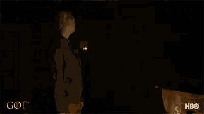 a woman is standing in a dark room with a hbo logo in the corner