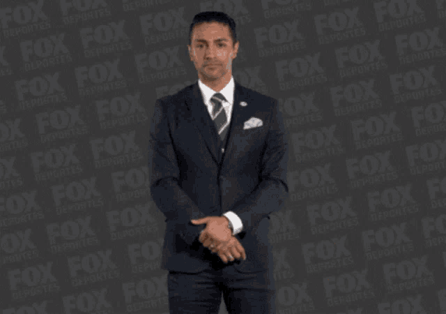 a man in a suit and tie is making a funny face in front of a fox logo